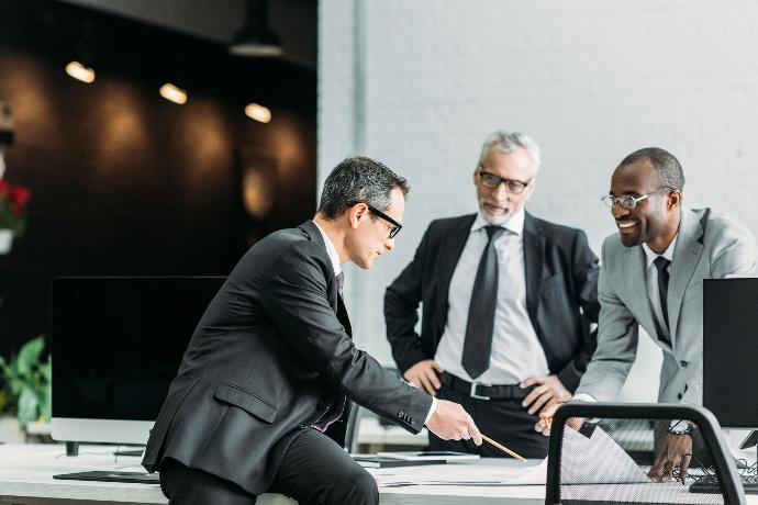 Plan contable de cada empresa Hombres en traje reunidos en oficina hablando